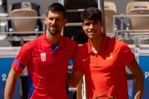 Novak Djokovic of Team Serbia and Carlos Alcaraz of Team Spain meet at the net prior to the Men's Singles Gold medal match on day nine of the Olympic Games Paris 2024 at Roland Garros on August 04, 2024 in Paris, France. (Photo by Tnani Badreddine/DeFodi Images via Getty Images)